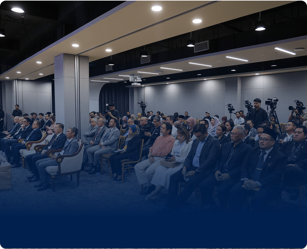 Conference room with attendees and cameras capturing the formal event.